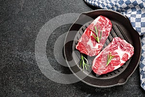 Fresh raw rib eye steaks on grill pan