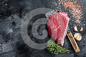 Fresh Raw rump beef cut or top sirloin cap steak on butcher cleaver. Black background. Top view. Copy space