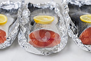 Fresh raw salmon fillet tail part with lemon on a light background. Pescatarian food menu, recipe. Red trout prepare in