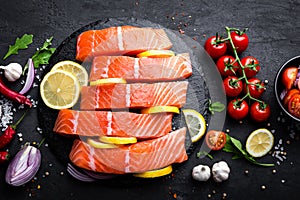 Fresh raw salmon red fish fillet on black background