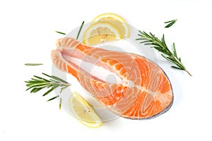 Salmon steak on a white background with lemon and spices