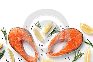 Fresh raw salmon steaks with rosemary and lemon on white background
