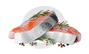Fresh raw salmon steaks with rosemary and peppercorns on white background