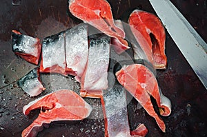Fresh raw salmon steaks with salt on the rustic table