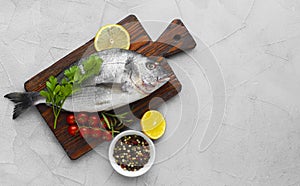 Fresh raw sea fish on wooden cutting board,brown wooden table