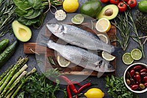 Fresh raw seabass and ingredients for cooking