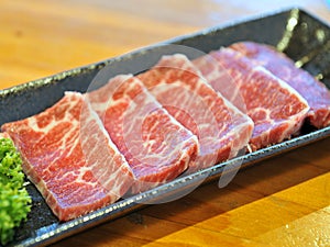 Fresh raw sliced beef on black platter