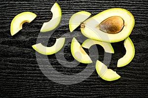 Fresh raw smooth avocado on black wood photo