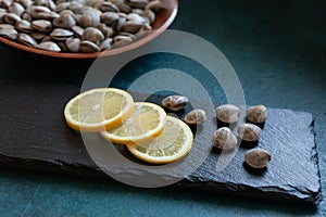 Fresh raw Surf chamelea gallina with lemon on the stone cutting board