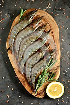 Fresh raw tiger shrimps rosemary and lemon. Top view. Copy space.