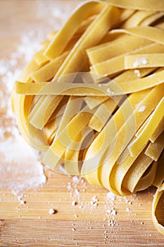 Fresh raw uncooked pasta - tagliatelle on a wooden board