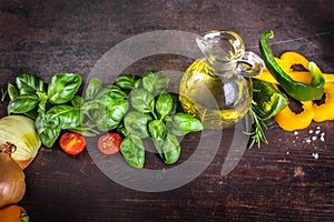 Fresh raw vegetable, herbs, olive oil, on a rustic wood board. Healthy cooking composition, food frame, with copy space.