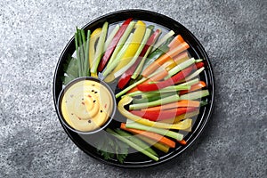 Fresh raw vegetable sticks and sauce on table, top view