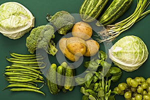 Fresh raw vegetables from the garden on a green background, top view, colorful concept, fresh raw vegetables