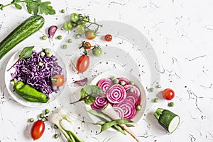 Fresh raw vegetables - red cabbage, beet, zucchini, green beans, tomatoes on a light background.