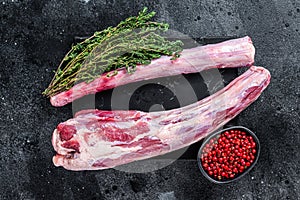 Fresh Raw whole Beef veal Oxtail Meat on marble board with herbs. Black background. Top view