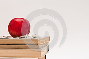 Fresh red apple, books, earphone.