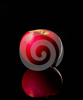 Fresh red apple with droplets of water against black background reflection drops fresh splash action movement