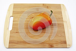 Fresh red bell pepper on bamboo cutting board