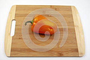Fresh red bell pepper on bamboo cutting board