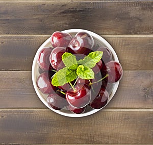 Fresh red cherries. Cherries in a bowl. Background of berries. Ripe cherry on wooden background.