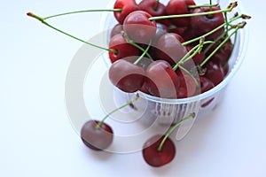 Fresh red cherries in a bowl on pink powder light background. Copy space, minimalistic style