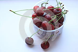 Fresh red cherries in a bowl on pink powder light background. Copy space, minimalistic style