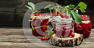 Fresh red cherries fruit on wooden background. Jar of cherry jam and sour cherries. Berries cherry with syrup. Canned fruit. place