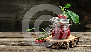 Fresh red cherries fruit on wooden background. Jar of cherry jam and sour cherries. Berries cherry with syrup. Canned fruit. place