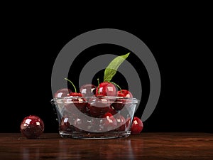 Fresh red cherries in a glass bowl on a wood tabletop