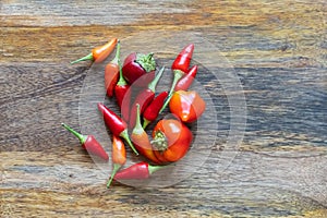 Fresh red chili peppers scattering on wood background close up