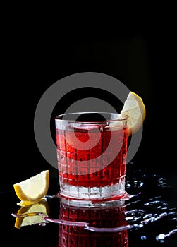 Fresh red colorful exotic alcoholic cocktail with lemon and ice