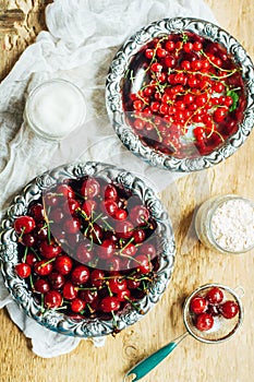 Fresh red currant on wooden table, bucket with red currant berri