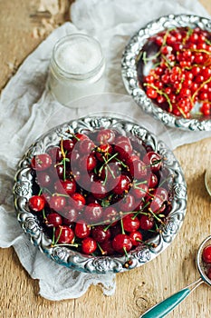 Fresh red currant on wooden table, bucket with red currant berri