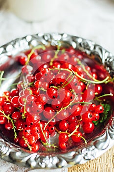 Fresh red currant on wooden table, bucket with red currant berri