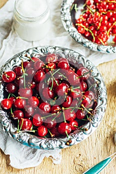 Fresh red currant on wooden table, bucket with red currant berri