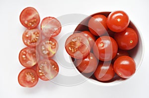 Fresh red fruits of small tomatoes on a glass plate. Juicy chopped cherry tomatoes