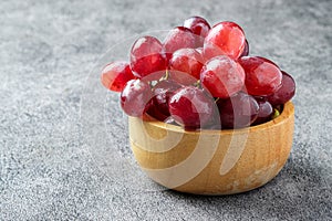 Fresh red grapes on a wooden cup