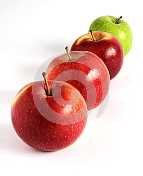 Fresh red and green apples diagonally on white