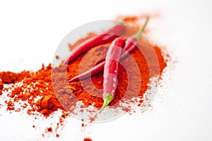 fresh red hot pepper and powder on a white background