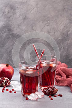 Fresh red lemonade with pomegranate and ice in glass