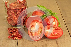 Fresh red paste tomatoes with basil and jar faded