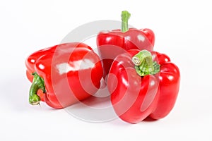 Fresh red peppers lying on white background, healthy nutrition concept