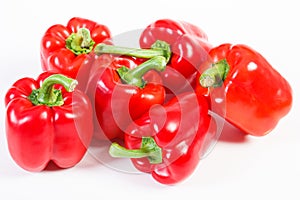 Fresh red peppers lying on white background, healthy nutrition concept