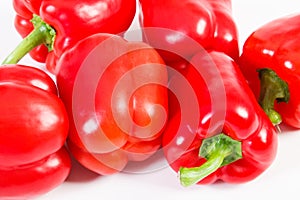 Fresh red peppers lying on white background, healthy nutrition concept