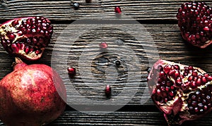 Fresh red pomegranate and grapefruit On a wooden background. Pomegranate in plate on wood background.