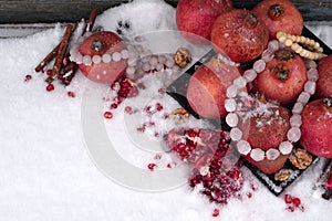 Fresh red  pomegranate and seed with cinnamon, beads from nature gem, nuts on  snow