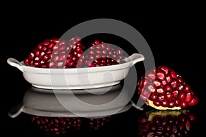 Fresh red pomergranate isolated on black glass