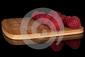 Fresh red raspberry isolated on black glass