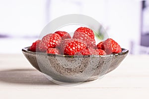 Fresh red raspberry with kitchen behind